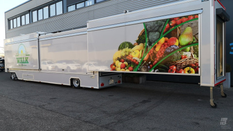 Zijaanzicht van een uitschuifbare aanhangwagen voor groente en fruit met gesloten luifel
