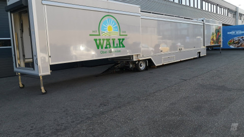 Zijaanzicht van een uitschuifbare aanhangwagen voor groente en fruit met gesloten luifel