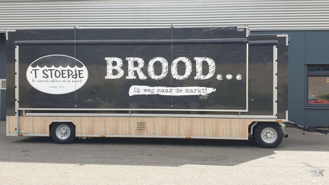 Zijaanzicht van een uitschuifbare aanhangwagen voor brood en banket met gesloten luifel