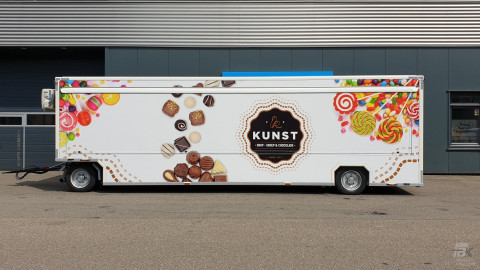Zijaanzicht van een aanhangwagen voor drop, snoep en chocolade met gesloten luifel