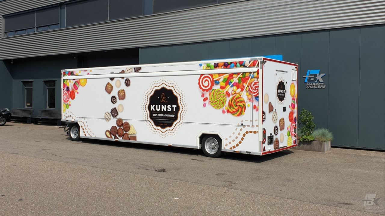 Zijaanzicht van een aanhangwagen voor drop, snoep en chocolade met gesloten luifel