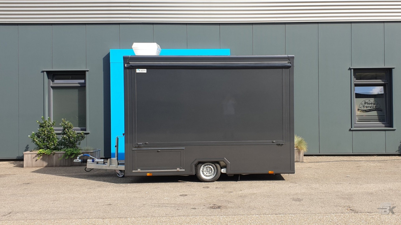 Zijaanzicht van een kleine aanhangwagen voor loempia's met gesloten luifel