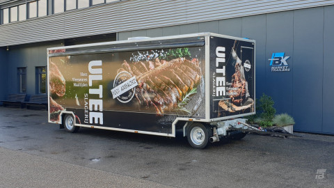 Zijaanzicht van een aanhangwagen voor vlees met gesloten luifel