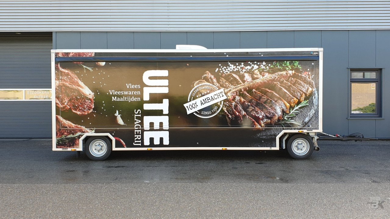 Zijaanzicht van een aanhangwagen voor vlees met gesloten luifel
