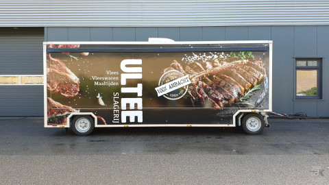 Zijaanzicht van een aanhangwagen voor vlees met gesloten luifel