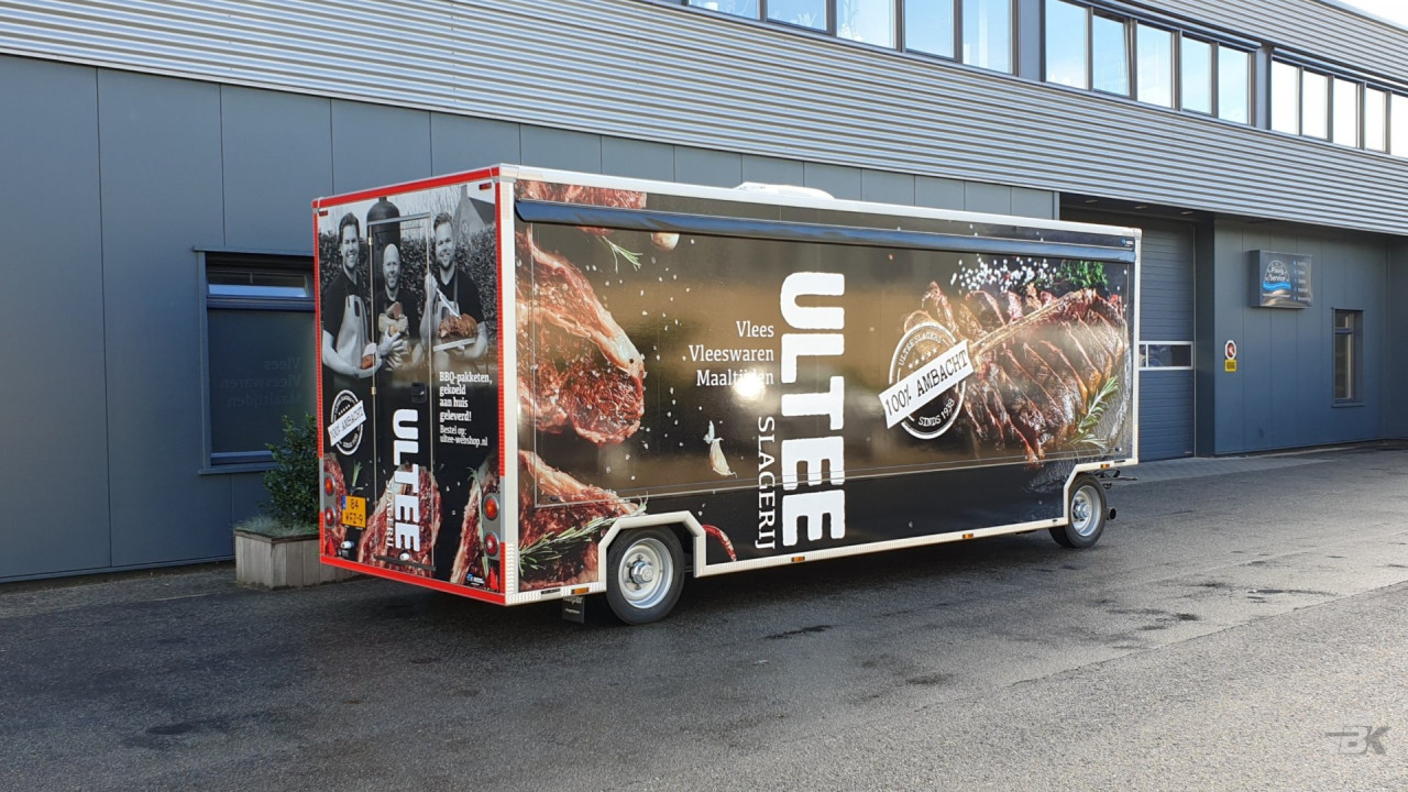 Zijaanzicht van een aanhangwagen voor vlees met gesloten luifel