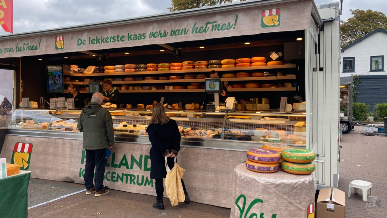 Volledig uitgestalde verkoopwagen voor kaas, op de markt