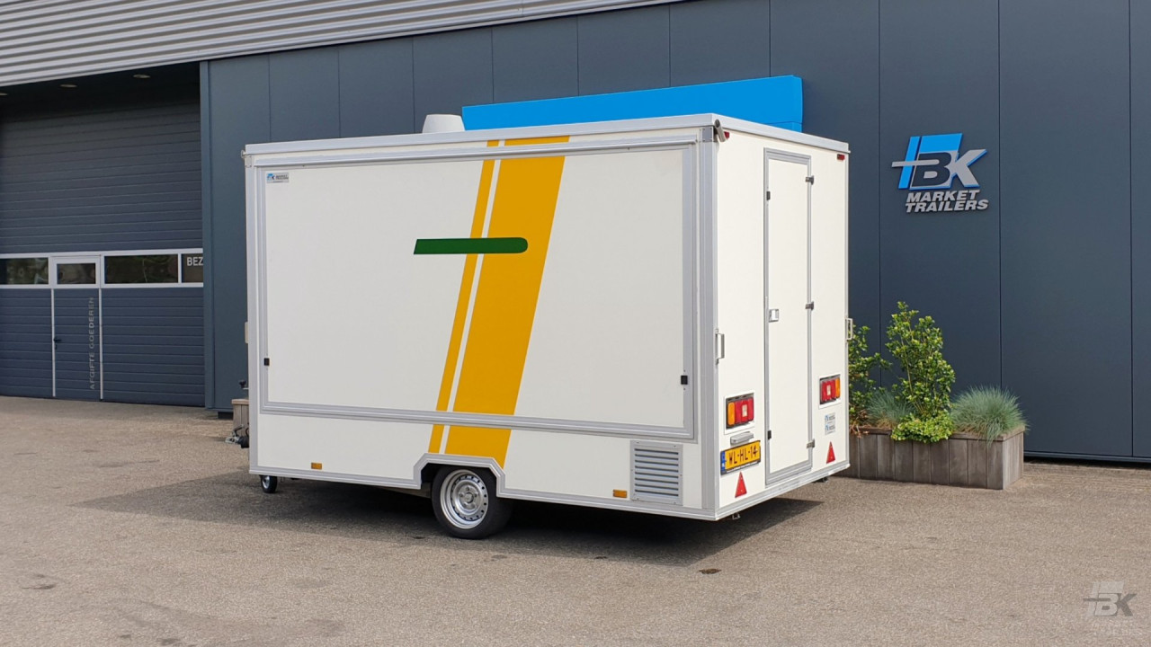 Zijaanzicht van een kleine aanhangwagen voor diverse branches met gesloten luifel