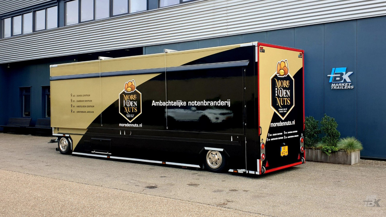 Zijaanzicht van een uitschuifbare aanhangwagen voor noten met gesloten luifel