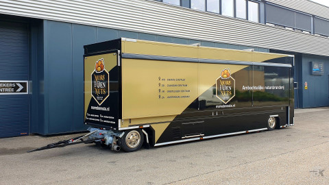 Zijaanzicht van een uitschuifbare aanhangwagen voor noten met gesloten luifel