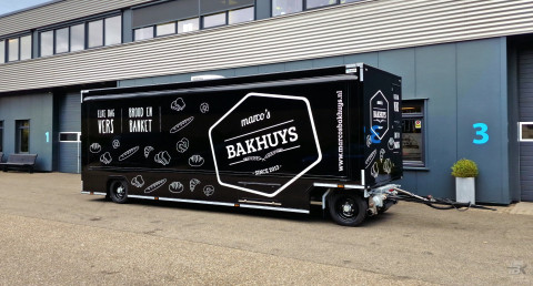 Zijaanzicht van een aanhangwagen voor brood en banket met gesloten luifel