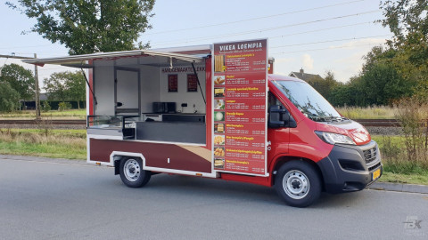 Zijaanzicht van een verkoopwagen voor loempia's met geopende luifel