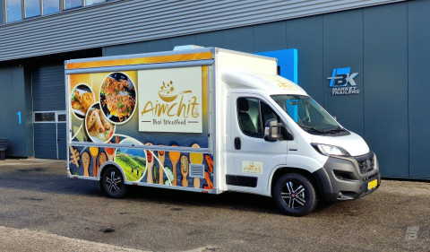 Zijaanzicht van een verkoopwagen voor streetfood met gesloten luifel