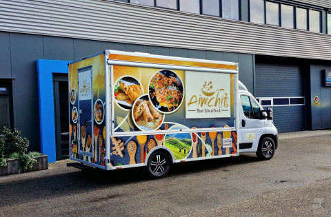 Zijaanzicht van een verkoopwagen voor streetfood met gesloten luifel