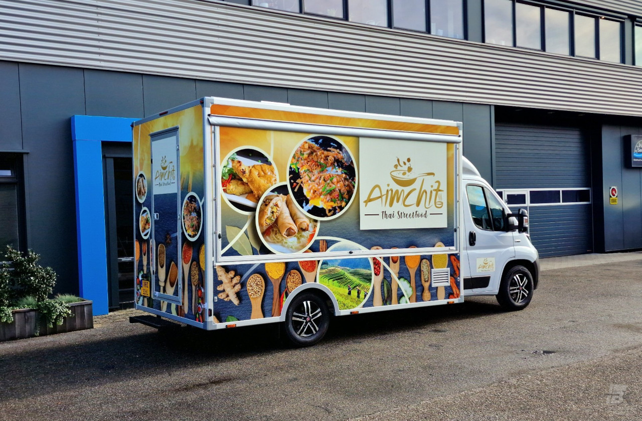 Zijaanzicht van een verkoopwagen voor streetfood met gesloten luifel