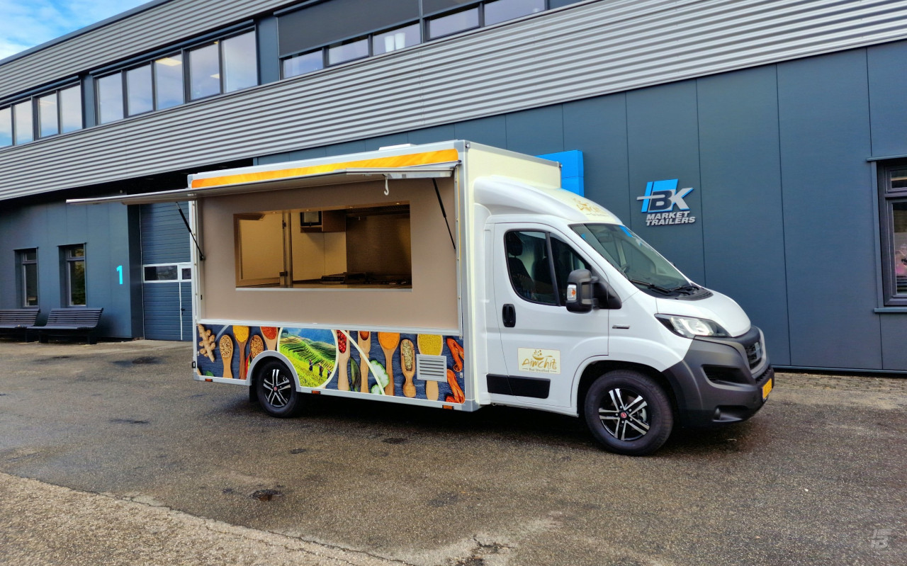Zijaanzicht van een verkoopwagen voor streetfood met geopende luifel