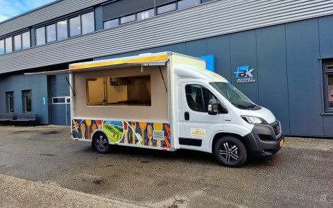 Zijaanzicht van een verkoopwagen voor streetfood met geopende luifel