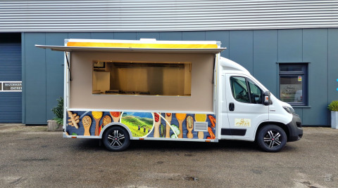 Zijaanzicht van een verkoopwagen voor streetfood met geopende luifel