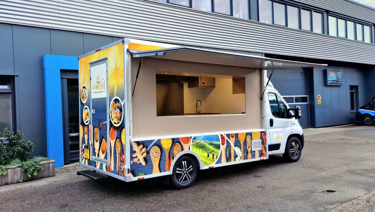 Zijaanzicht van een verkoopwagen voor streetfood met geopende luifel