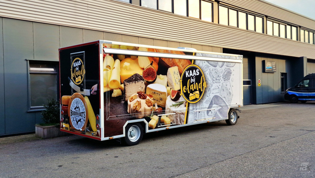 Zijaanzicht van een verkoopwagen voor kaas met gesloten luifel