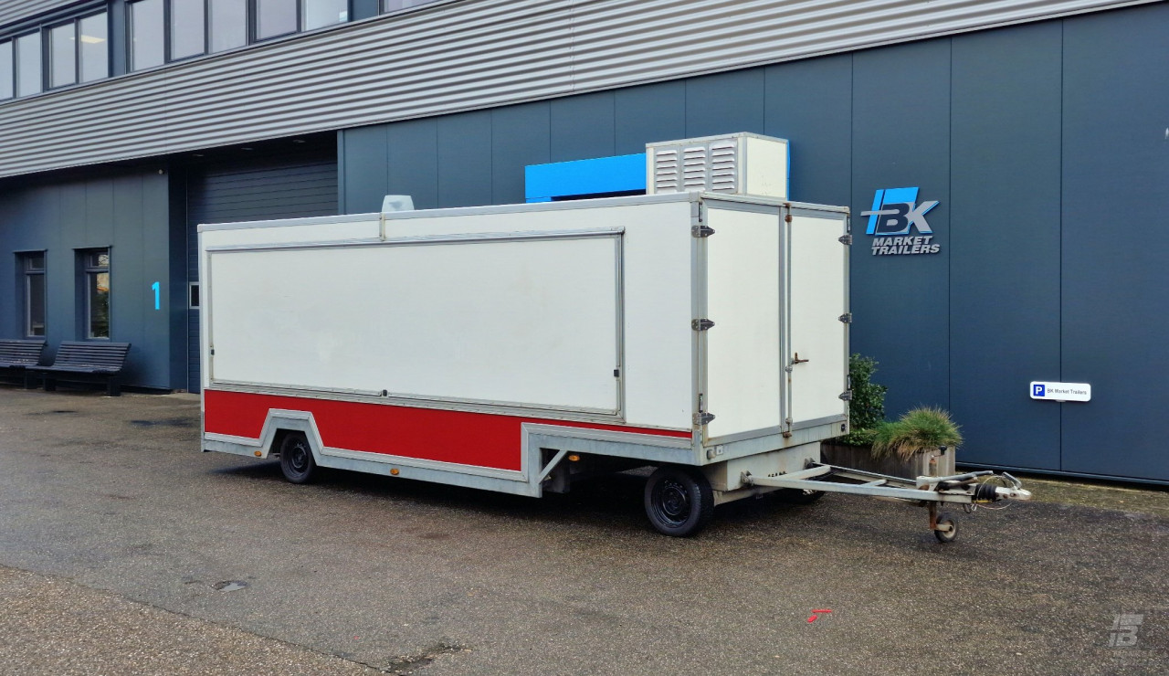 Zijaanzicht van een aanhangwagen voor diverse branches met gesloten luifel