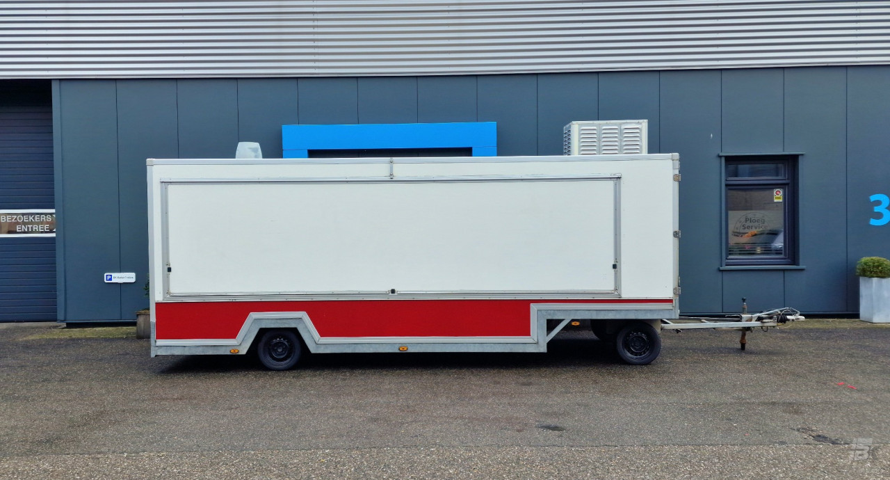 Zijaanzicht van een aanhangwagen voor diverse branches met gesloten luifel