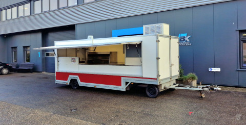 Zijaanzicht van een aanhangwagen voor diverse branches met geopende luifel