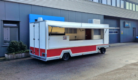 Zijaanzicht van een aanhangwagen voor diverse branches met geopende luifel