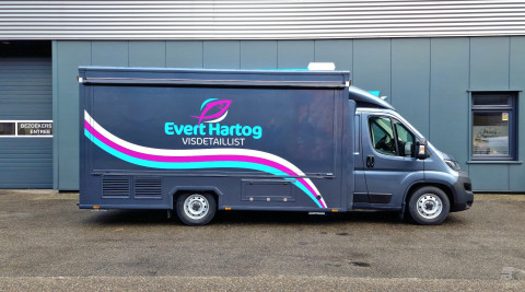 Zijaanzicht van een verkoopwagen voor vis met gesloten luifel