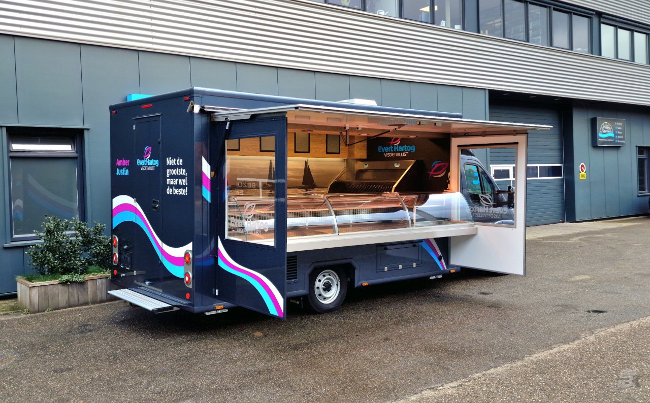 Zijaanzicht van een verkoopwagen voor vis met geopende luifel en zijborden