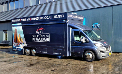 Zijaanzicht van een verkoopwagen voor vis met gesloten luifel