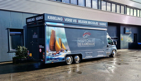 Zijaanzicht van een verkoopwagen voor vis met gesloten luifel
