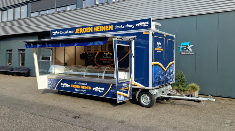 Zijaanzicht van een aanhangwagen voor vis met geopende luifel en zijborden