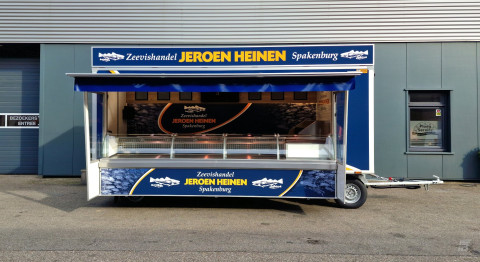 Zijaanzicht van een aanhangwagen voor vis met geopende luifel en zijborden