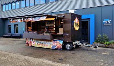 Zijaanzicht van een aanhangwagen voor kip aan het spit met geopende luifel