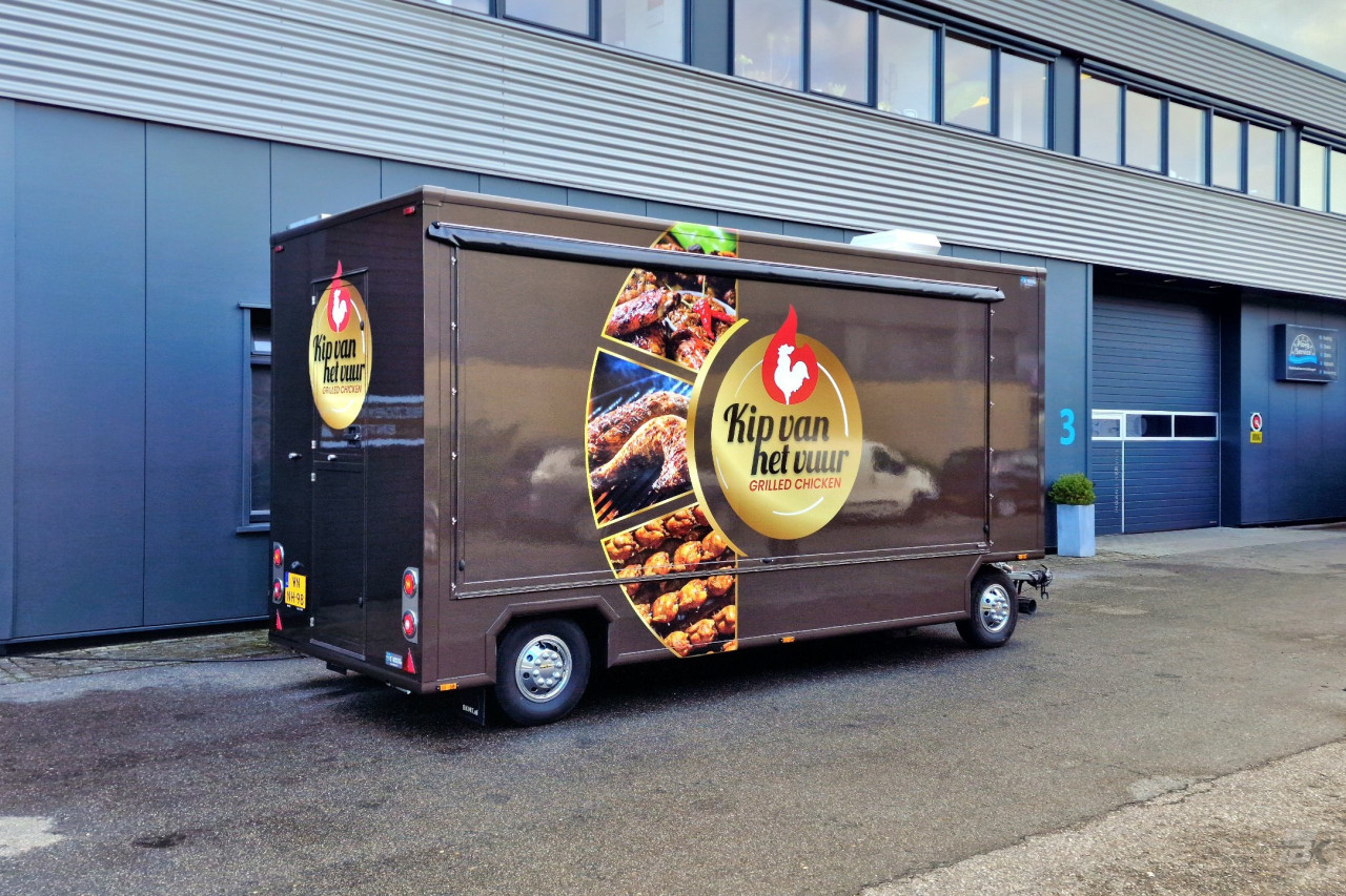 Zijaanzicht van een aanhangwagen voor kip aan het spit met gesloten luifel
