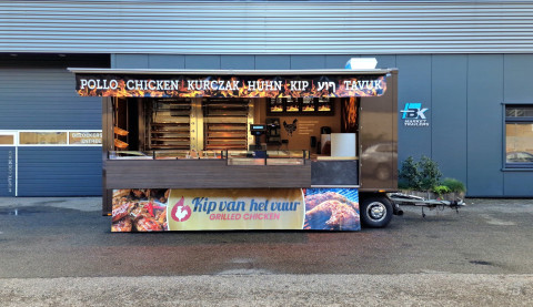 Zijaanzicht van een aanhangwagen voor kip aan het spit met geopende luifel