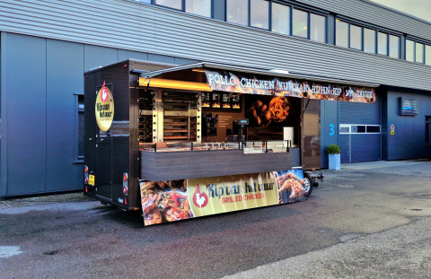 Zijaanzicht van een aanhangwagen voor kip aan het spit met geopende luifel