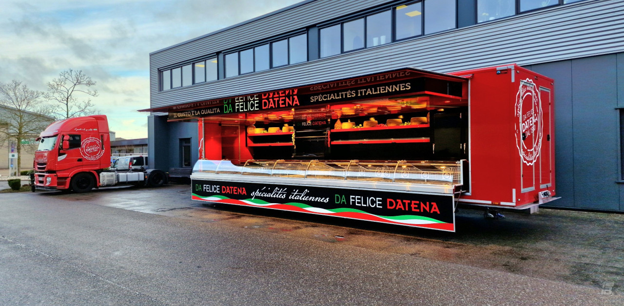 Zijaanzicht van een verkoopwagen oplegger voor Italiaanse delicatessen met geopende luifel