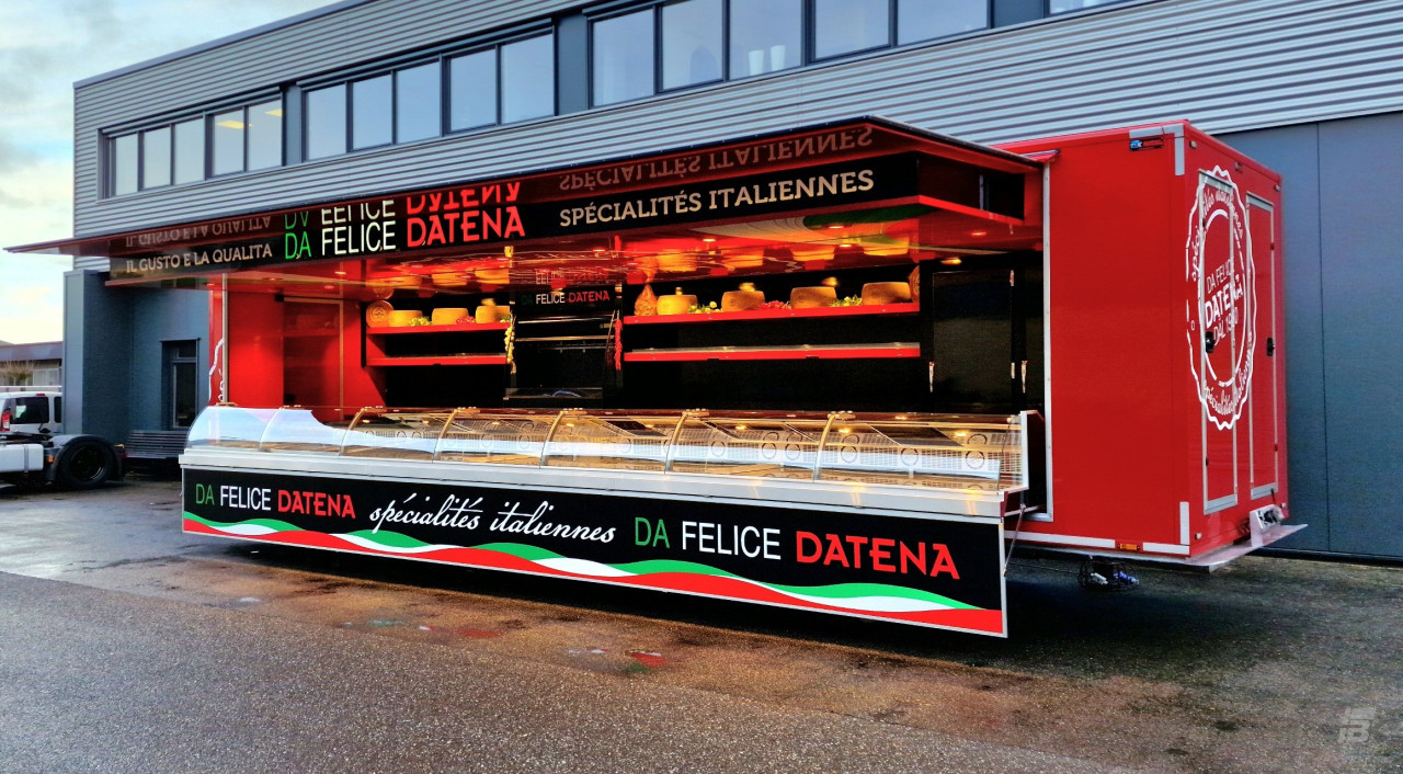 Zijaanzicht van een verkoopwagen oplegger voor Italiaanse delicatessen met geopende luifel