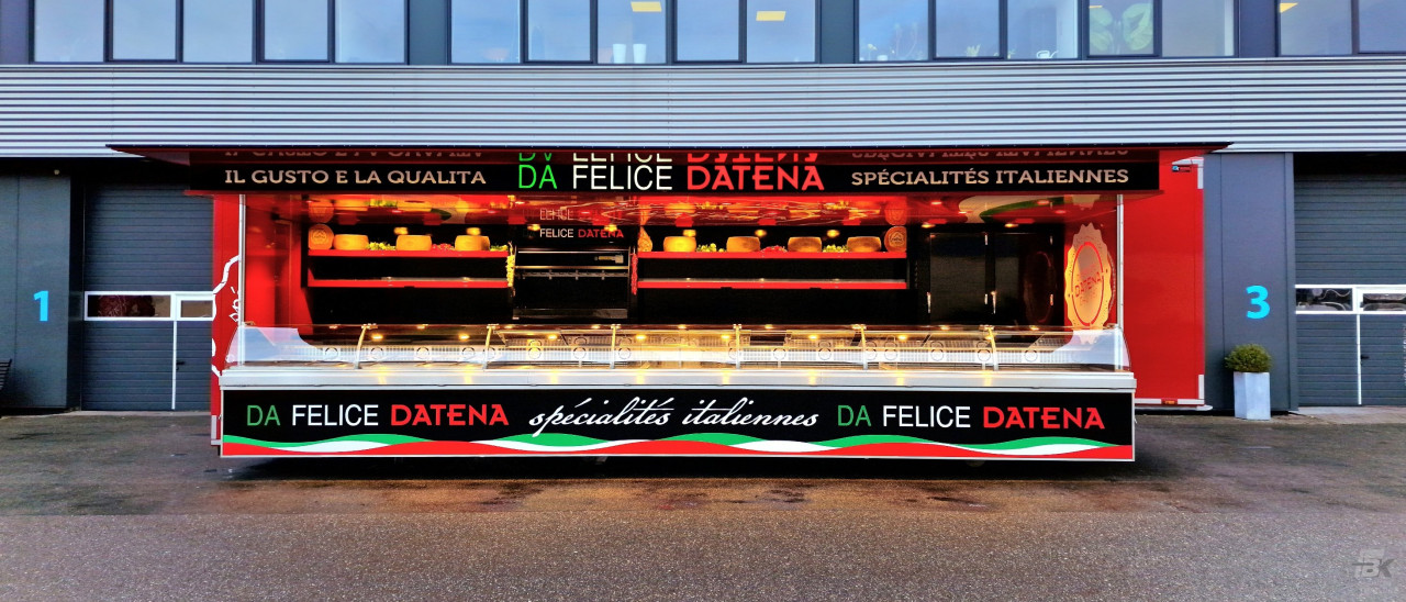 Zijaanzicht van een verkoopwagen oplegger voor Italiaanse delicatessen met geopende luifel