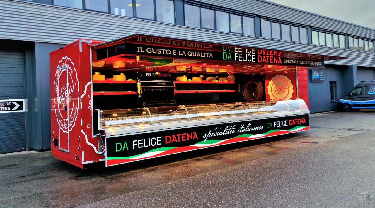 Zijaanzicht van een verkoopwagen oplegger voor Italiaanse delicatessen met geopende luifel