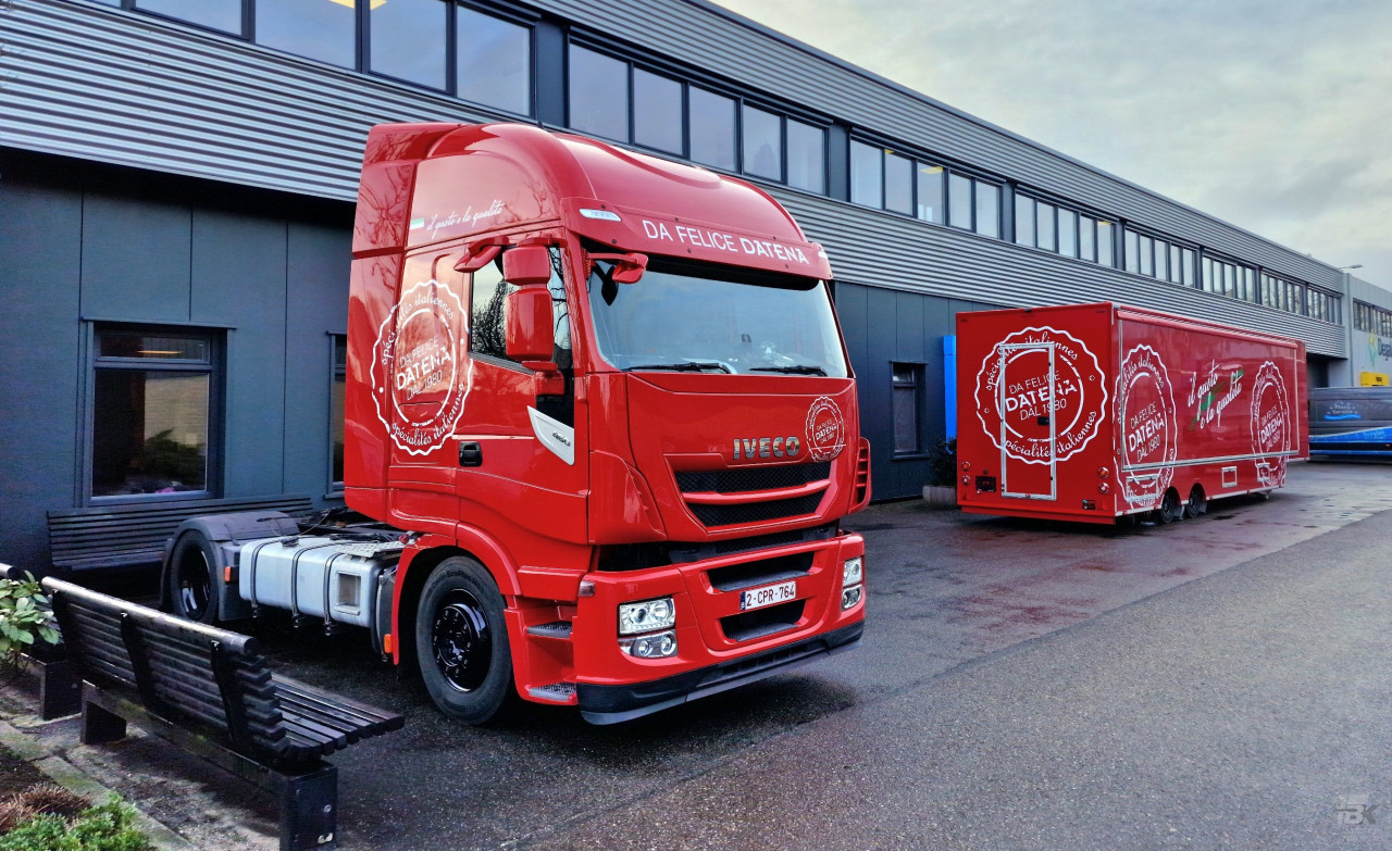 Vooraanzicht van een opleggertrekker, met op de achtergrond een verkoopwagen oplegger voor Italiaanse delicatessen
