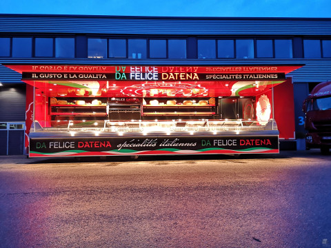 Zijaanzicht van een verkoopwagen oplegger voor Italiaanse delicatessen met geopende luifel en verlichting