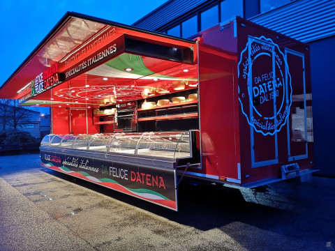 Zijaanzicht van een verkoopwagen oplegger voor Italiaanse delicatessen met geopende luifel en verlichting