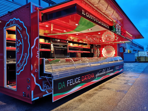 Zijaanzicht van een verkoopwagen oplegger voor Italiaanse delicatessen met geopende luifel en verlichting