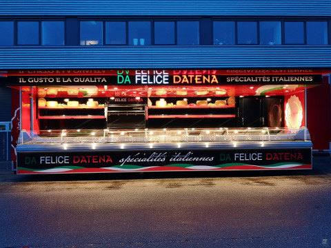Zijaanzicht van een verkoopwagen oplegger voor Italiaanse delicatessen met geopende luifel en verlichting