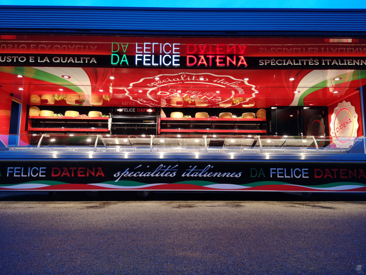 Zijaanzicht van een verkoopwagen oplegger voor Italiaanse delicatessen met geopende luifel en verlichting