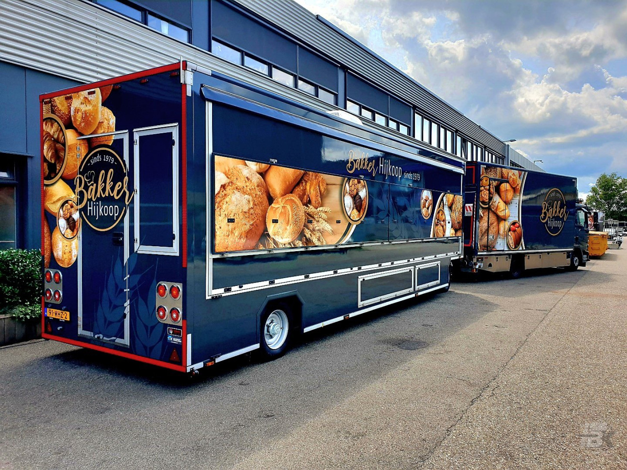 Zijaanzicht van twee verkoopwagens voor brood en banket met gesloten luifels