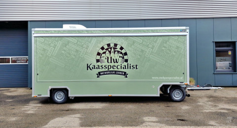Zijaanzicht van een aanhangwagen voor kaas met gesloten luifel